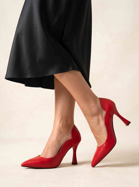Kırmızı sivri burun stiletto ayakkabı adım atarken, bilekte kavisli dekolte kesim ve ince topuk yandan