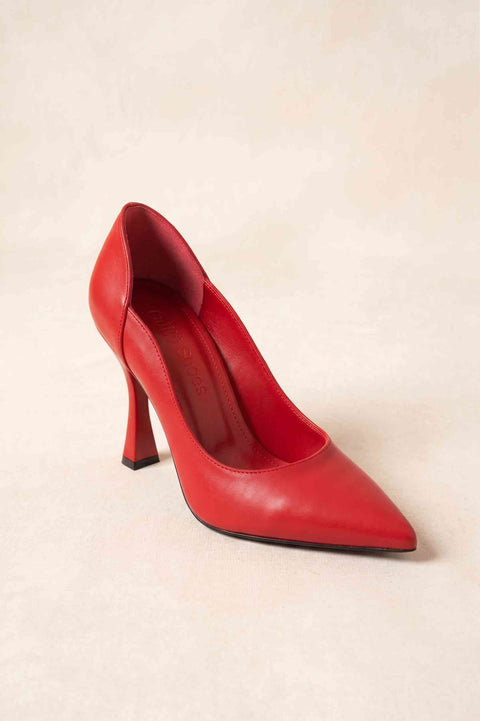Tek kırmızı stiletto ayakkabı üstten çapraz görünüm, kavisli dekolteli yan hat ve sivri burun detayı
